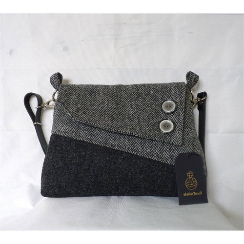 Dark grey and herringbone Harris Tweed shoulder bag with an adjustable black leather strap and a black lining with a zipped pocket