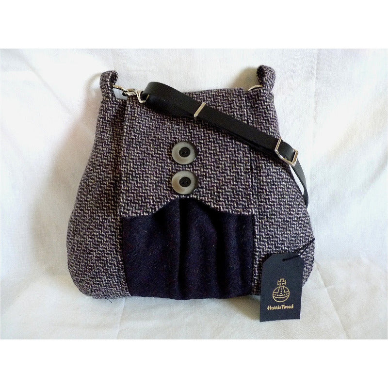 Purple, black & pink harris tweed poacher bag with an adjustable black leather strap and a black lining with a zipped pocket